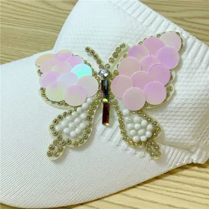 Primo piano dettagliato di una visiera bianca con una farfalla scintillante di strass e perle.