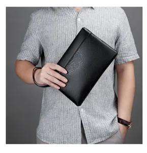 Black leather men's clutch bag with stylish embossed circular medallion design for business.
