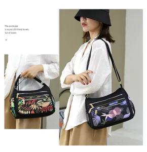 Multi-layer nylon crossbody bag with chic abstract print, convenient shoulder strap for women.
