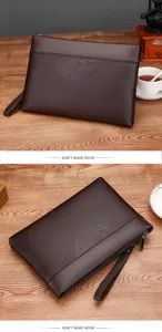 Men's brown leather clutch detail showing embossed circular pattern, durable zipper and wrist strap.