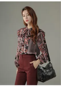 Detailed view of women's floral print long sleeve blouse and stylish shoulder bag outfit.