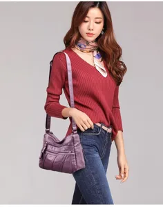 Detail view of women washed soft leather shoulder bag, casual crossbody design with multi zippers.