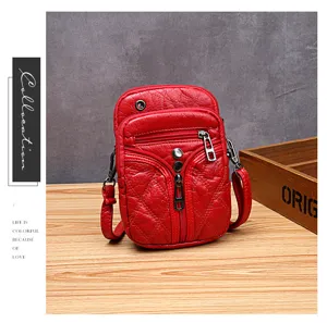 Bolso cruzado rojo de cuero suave con múltiples compartimentos con cremallera para el uso diario.
