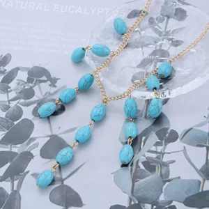 Detailed view of vintage turquoise oval beads on a delicate gold-tone adjustable necklace.
