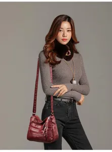 Detail view of women's soft washed leather crossbody shoulder bag with multi zipper pockets.