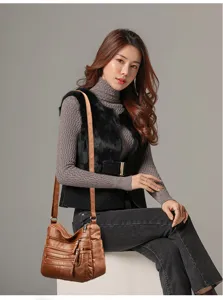 Soft leather shoulder bag detail view showcasing multi pocket design and elegant wearing style.