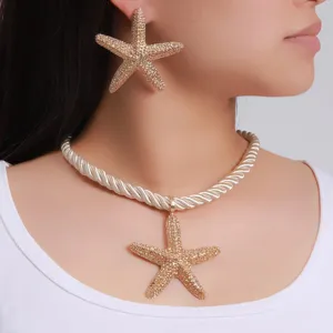 Nahaufnahme eines Models mit einer goldenen Seestern-Halskette und passenden Ohrringen.