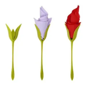 Detail view of creative green tulip shaped napkin holder and paper flower folding tool.