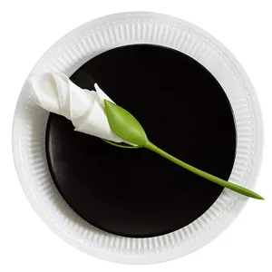 Detail shot of green flower napkin holder holding white napkin on elegant plates, table decor.