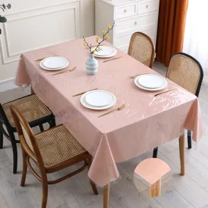Vue détaillée de la nappe en PVC transparent texturé rose disposée sur une table à manger.