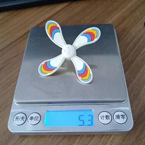 Detail shot of cute colorful rotating windmill shoe charm on digital scale showing weight.