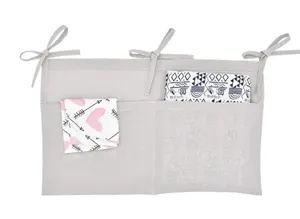 Linen baby crib hanging organizer with double pockets and ties for nursery storage.