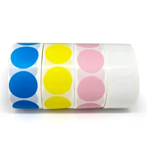 Gros plan de rouleaux d'autocollants en papier à points ronds colorés, bleu, jaune, rose.