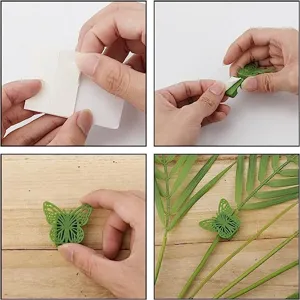 Detail view of green butterfly plant climbing clip showing adhesive application and stem fixing.