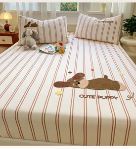 Detailed view of cotton striped fitted bed sheet featuring cute puppy embroidery and matching pillows.