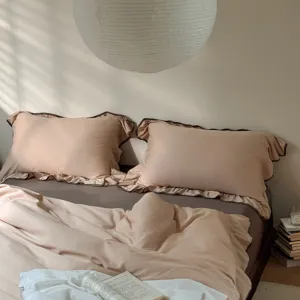 Cozy cotton bedding set detail showcasing soft ruffled pillowcases and elegant color-blocked trim.
