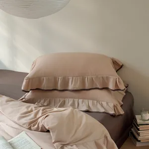 Detail view of solid color cotton bedding set, featuring elegant ruffled edges and soft texture.