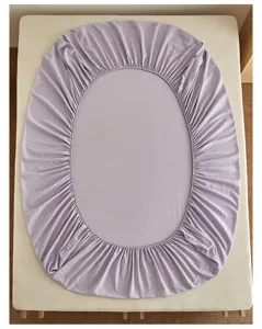 Detailansicht eines weichen lavendelfarbenen Spannbettlakens mit elastischen Kanten für das matras.