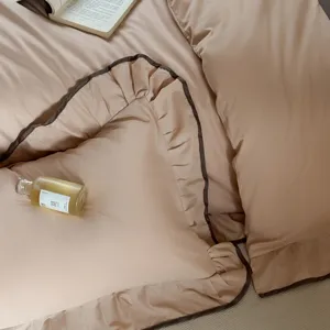 Detailed view of luxury cotton bedding set with elegant brown piped ruffles and duvet cover.