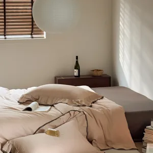 Cotton bedding detail shot featuring solid color duvet cover with elegant dark piping and ruffles.