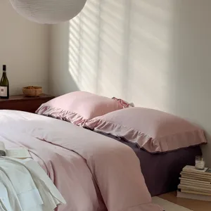 Detailed view of the pink cotton ruffle duvet cover and purple bed sheet set in bedroom