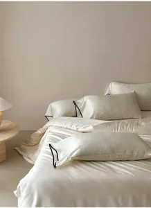 Silky tencel bedding set detail view featuring elegant black piping and jacquard texture.