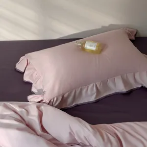 Pink ruffled cotton pillowcase and purple bedding set detail, soft fabric for all seasons comfort.