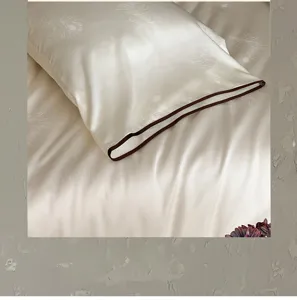 Close-up detail of luxurious silky white tencel bedding pillowcase with feather jacquard texture.