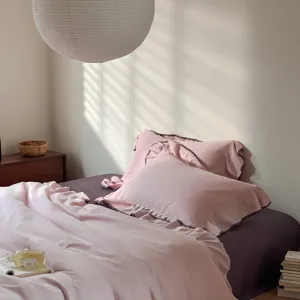 Cozy pink cotton bedding set with elegant ruffled pillowcases for a warm bedroom style.