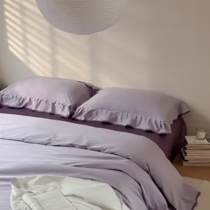 Cozy purple cotton bedding set detail, solid color duvet cover with elegant ruffles.