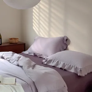 Purple cotton ruffled bedding set detail, solid color duvet cover and pillowcases for bedroom.