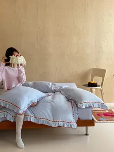 Juego de ropa de cama de algodón arrugado azul con bonitos volantes y lazos para dormitorio.