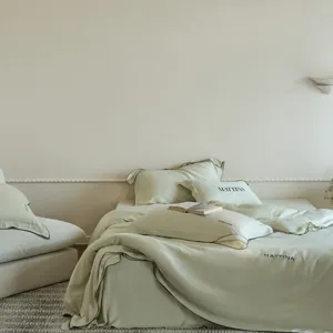 Detail view of high-end solid color tencel four-piece bedding set with elegant black piping.