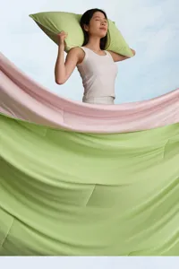 Vista detallada de la suave manta de verano refrescante con una textura verde y rosa elegante.