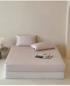 Seidiges rosa Spannbetttuch mit passenden Kissenbezügen im Detail für komfortables Schlafzimmer.