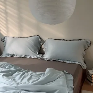 Light blue bedding set with brown ruffles, duvet cover and pillowcases for cozy bedroom decor.
