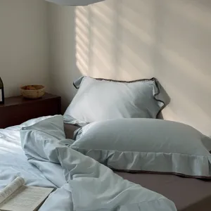 Light blue cotton 4-piece bedding set with dark brown ruffles, cozy bedroom scene detail view.
