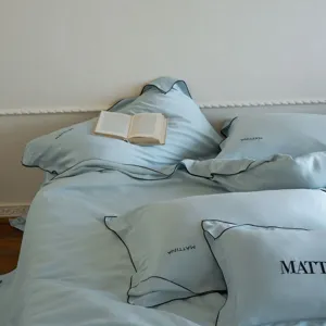 Luxurious light blue lyocell bedding set detail, smooth silk touch duvet and embroidered pillow.