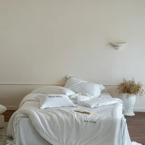 Luxury silk-like tencel four-piece bedding set with elegant black piping and minimalist style.