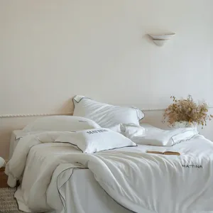 High-end Tencel Lyocell 4-piece bedding set in solid white with elegant black piping detail.