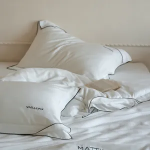 White Tencel lyocell bed linen set with elegant black piping and minimalist lifestyle.