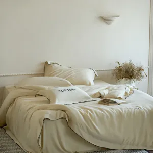 Detailed view of luxury silk tencel bedding set in solid beige with black trim.