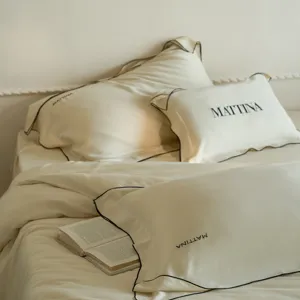 Luxury sand-washed Tencel bedding detail, smooth ice silk lyocell fabric with black piping.