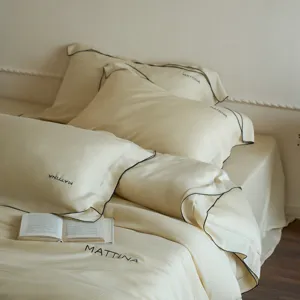 Detailed view of luxury silk-like lyocell bedding set in cream tone with delicate embroidery.