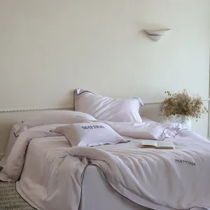 Detailed view of luxury washed tencel 4-piece bedding set in solid pink with elegant black piping.