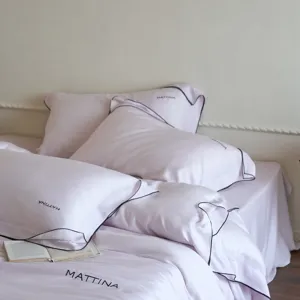 Luxurious silk-like tencel bed linen set detail view with elegant black trim and soft texture.