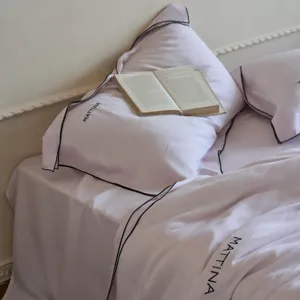 Luxury tencel lyocell bedding set with elegant black piping and delicate embroidery detail.