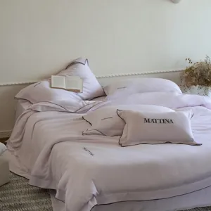 Close-up of luxury Tencel bedding set detail, smooth pink Lyocell fabric with black trim.