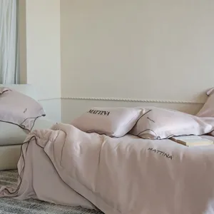 Detailed view of luxury tencel bedding set with elegant black piping and soft silk-like texture.