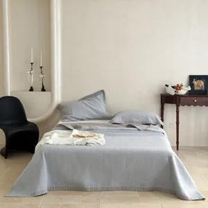 Detailaufnahme des gesteppten Baumwoll-Tagesdecken-Sets im gemütlichen Schlafzimmer.